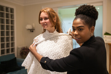 Fashion Stylist Assisting Woman with Bridal Dress Fitting