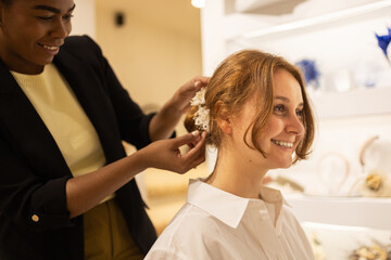 Woman gets final touches on hair with floral accessory