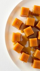 Top view of caramel cubes on a white background, ideal for food bloggers and recipes, candy, caramel