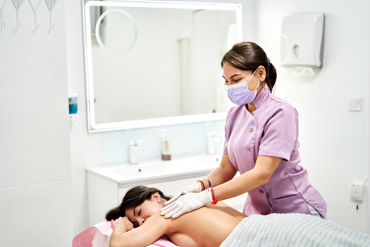 A therapist provides a massage to a client in a serene beauty salon