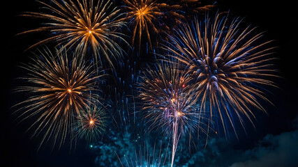 From below, shot of stunning brilliant fireworks erupting on the background of black night sky.