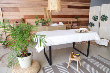 Interior of spa salon with massage couch and shelf units