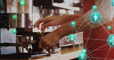Barista inserting portafilter into espresso machine at cafe counter, overlaying green network icons - Powered by Adobe