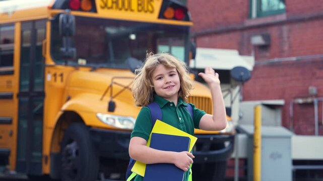 School kid waving hand near school bus. Child go to school bus. American education scene. School moment. USA childhood memory. Learning today. Child with sook and backpack ready to study.