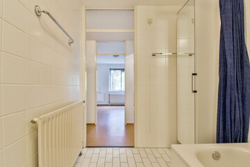 A spacious modern bathroom featuring a sleek shower area, a stylish curtain, and minimalist design elements. The neutral tones create a tranquil atmosphere.