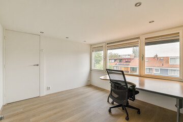 A spacious and minimalistic office interior featuring large windows that allow natural light to flood in, creating an open and inviting atmosphere.