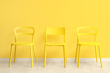 Stylish chair near yellow wall in room