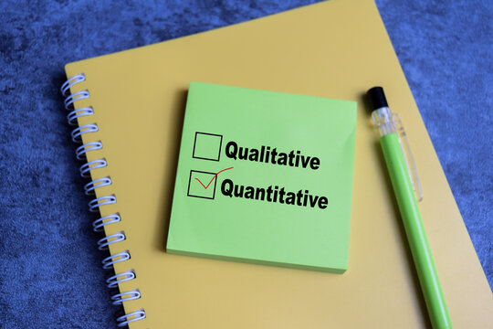 Concept of one person is answering question. he is choosing between qualitative and quantitative write on sticky notes isolated on Wooden Table.