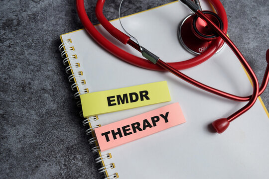 Concept of EMDR - Eye Movement Desensitization and Reprocessing Psychotherapy treatment - EMDR therapy write on sticky notes and isolated on Wooden Table.