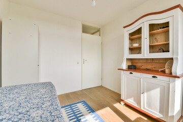 A cozy interior featuring a minimalist approach with light-colored walls and wooden accents,...