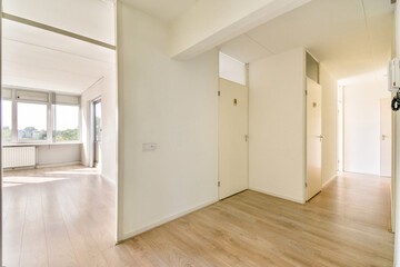 A bright and spacious modern hallway featuring large windows, light wood flooring, and minimalist decor. The design highlights simplicity and functionality.