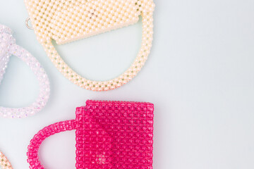 Handmade bags made from beads scattered on a blue background.