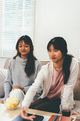 Female higher education student using laptop and studying book in home, Online learning.