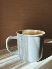 Fototapete Rund cup of coffee on wooden table with abstract shadows © chalyshevae
