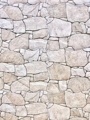 Rough uneven strong stone wall surface texture isolated on vertical ratio background.