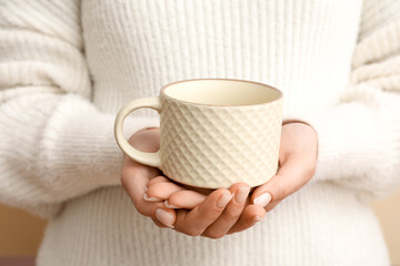 Woman holding white ceramic mug, closeup