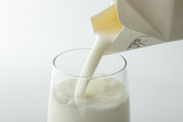 紙パック牛乳をグラスに注ぐ