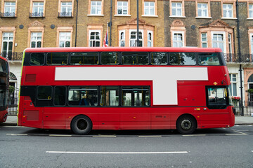 The blank ad space on the red bus contrasts with the classic charm of the calm London street. © Surachetsh