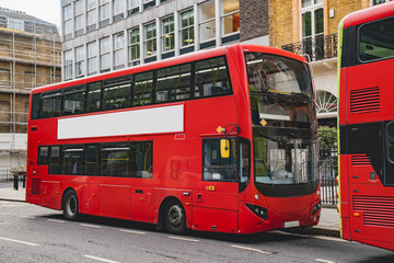 The blank ad space on the red bus contrasts with the classic charm of the calm London street.