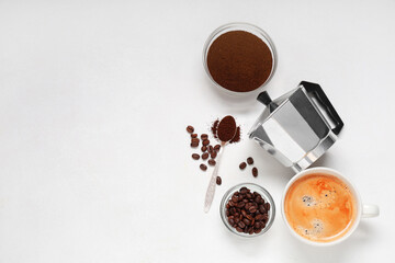 Cup of coffee with powder, beans and geyser coffee maker on white background