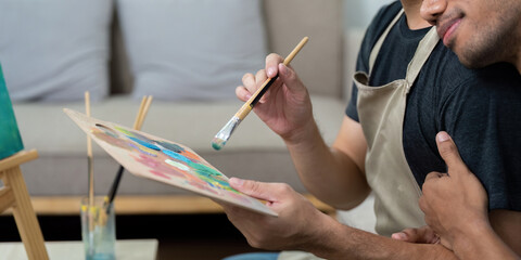 Couple and Artistic Bond. A gay couple collaborating on a colorful painting, showcasing their love and creativity.