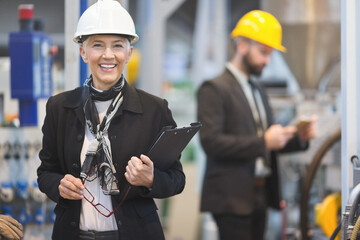Quality inspectors team and workers at factory using machines