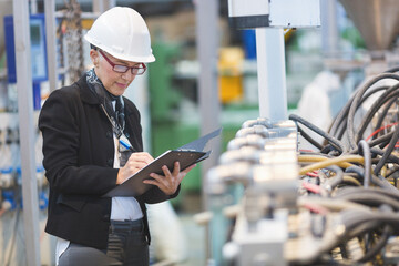 Quality inspectors team and workers at factory using machines