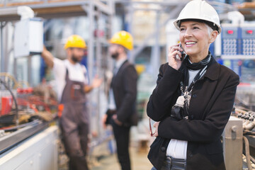 Quality inspectors team and workers at factory using machines