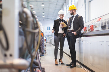 Obraz premium Quality inspectors team and workers at factory using machines