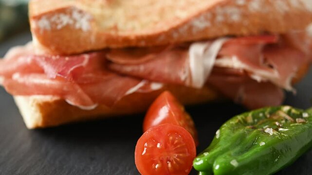 Spanish serrano ham sandwich on wooden table. Spanish bocadillo de jamon serrano