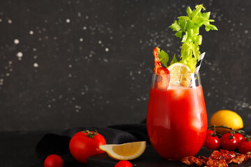 Glass of bloody mary cocktail with bacon, celery and lemon on black background