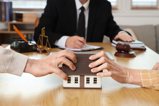 Mature couple dividing house at divorce lawyer's office, closeup