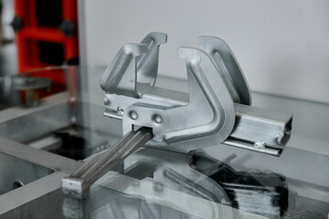 A close-up of a metal formwork clamp used in concrete construction.