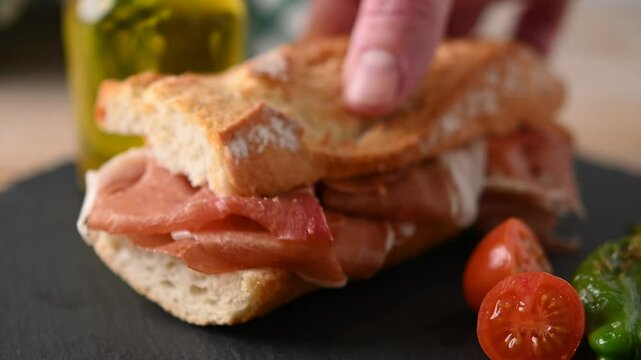 Spanish serrano ham sandwich on wooden table. Spanish bocadillo de jamon serrano