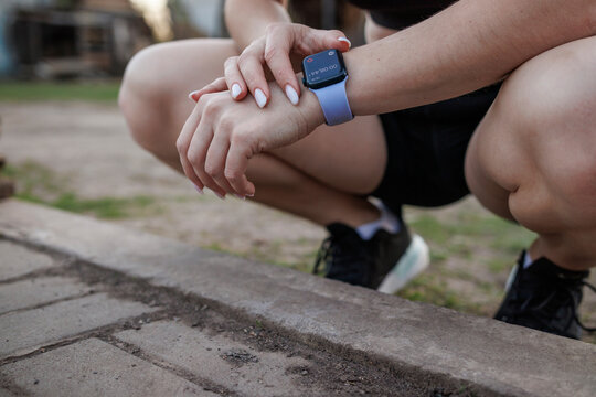 young girl checking the timer on her watch after outdoor training