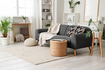 Interior of living room with sofa, basket and shelf units