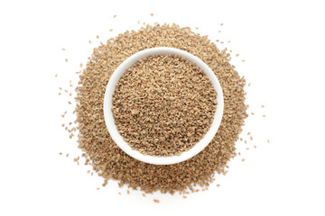 A bowl of Organic Carom seeds (Trachyspermum ammi) or Ajwain, placed over a heap of whole Carom seeds. Isolated on a white background.