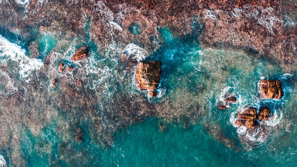 Blue waves hit rocky cliffs. perfect for summer scenes and nature backgrounds.