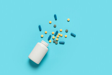 Jar with different pills on blue background