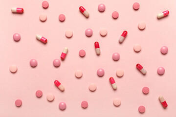 Different pink pills on color background