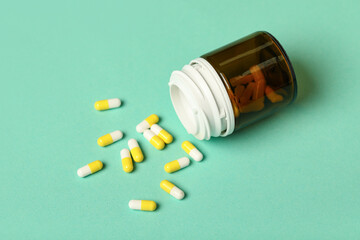 Jar with hard capsules on green background, closeup