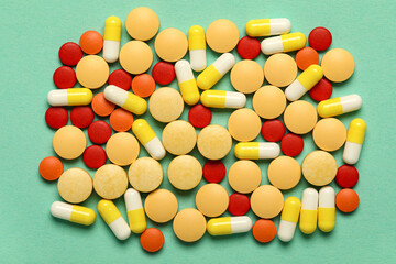 Different pills on green background