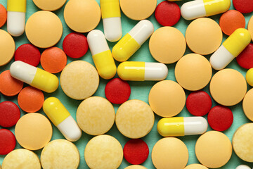 Different pills on green background