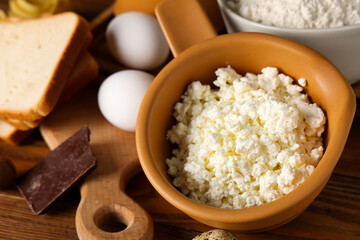 Cottage cheese with eggs and bread on wooden table, closeup. Food Allergy Awareness Month
