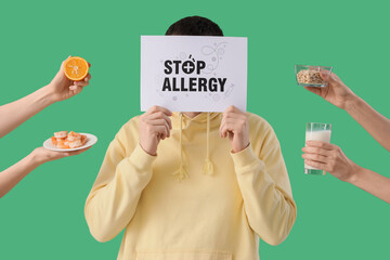 Young man with text STOP ALLERGY and female hands holding food products on green background