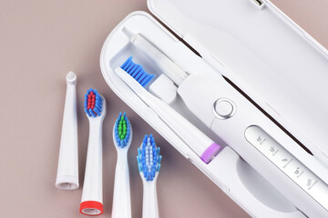 Modern electric ultrasonic toothbrush with rechargeable battery on a gray surface.