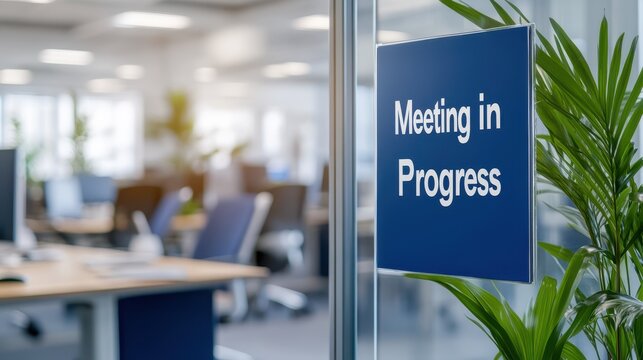 Door sign on an office glass wall indicating "Meeting in Progress," creating a professional atmosphere for ongoing discussions within the workspace.