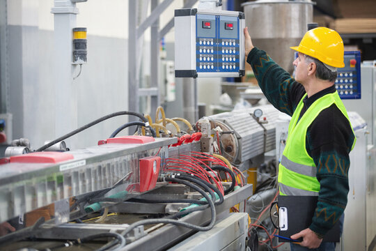 Senior worker in the factory operating machines