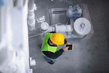 Senior worker in the factory operating machines high angle view