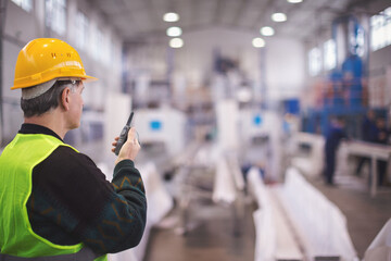 Senior manager talking on walkie talkie in factory